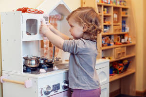 Child playing with toy kitchen 